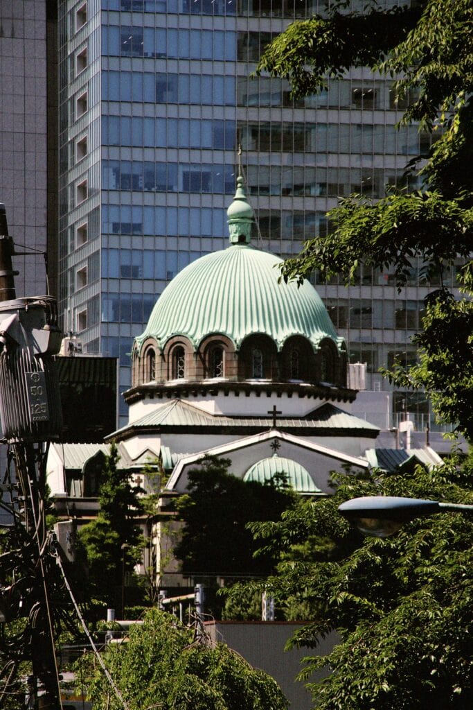Ancient-style dome amidst modern skyscrapers in Tokyo, blending traditional architecture with urban.