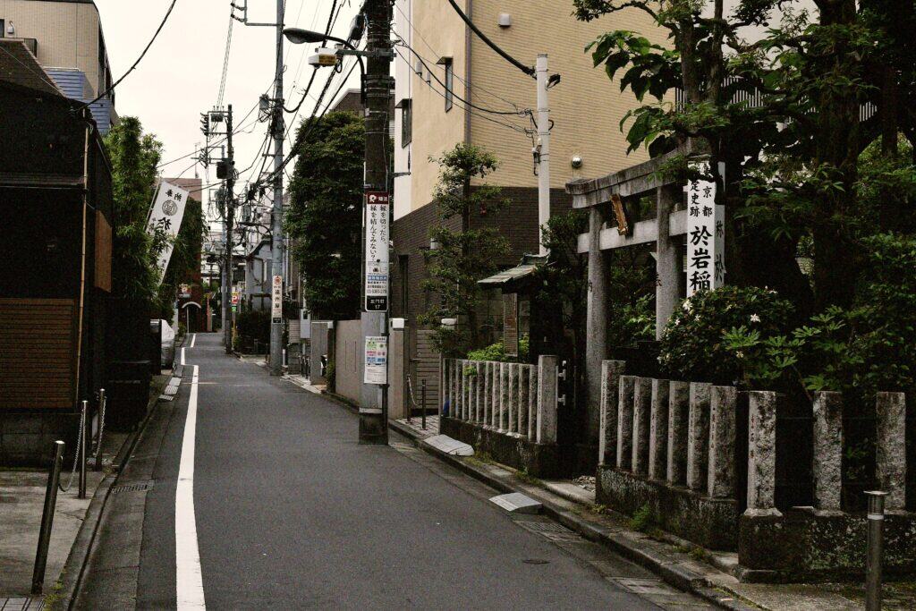 Small shrine in Tokyo's Yotsuya area with traditional torii gate and stone lanterns.